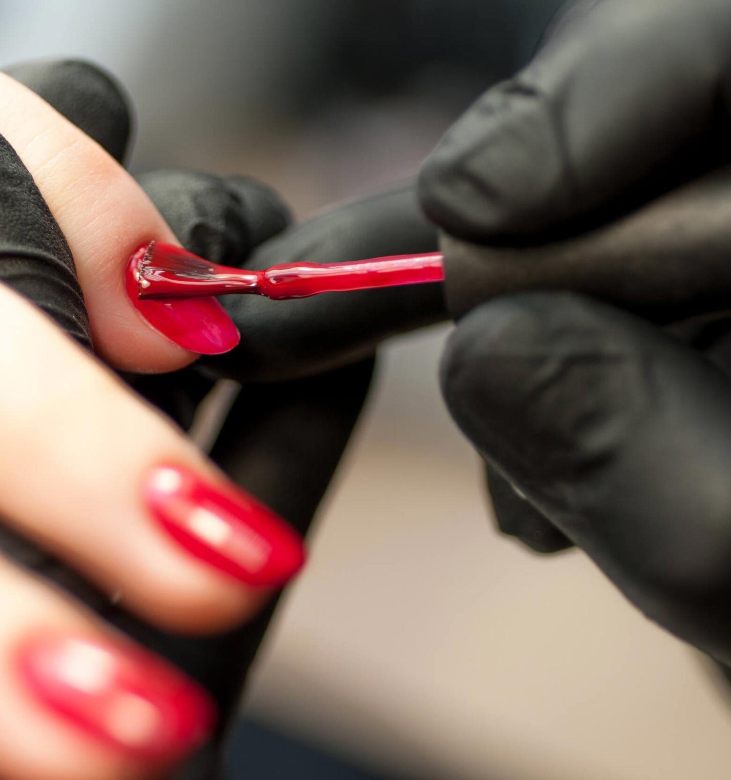 Nail technician painting client's nails